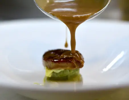 Imagen que muestra un cazo salseando una comida delicatessen en AZ Gastronomía