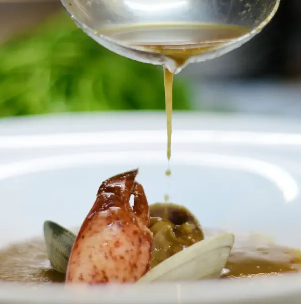 Imagen del procedimiento de salseo de un plato de marisco